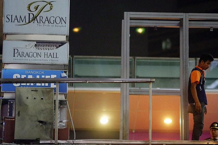 A man works at the site of a blast on an elevated walkway linking an overhead rail line to the Siam Paragon mall in central Bangkok on Feb 2, 2015. Two pipe bombs exploded outside the luxury shopping mall in Bangkok on Sunday in an attack which Thai 