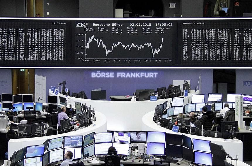 Traders work at their screens in front of the German share price index DAX board at the stock exchange in Frankfurt on Feb 2, 2015.&nbsp;European stocks rose early on Tuesday, Feb 3, lifted by hopes for an agreement on the Greek debt stand-off after 