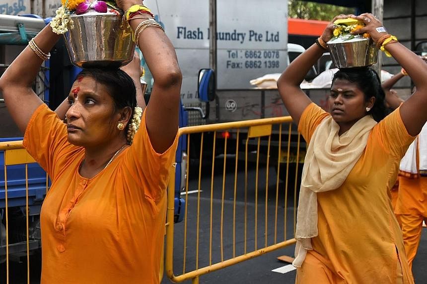 Hindu devotees carrying offerings of milk along a procession route in Singapore's Little India district as part of the annual Thaipusam festival on Feb 3, 2015. -- PHOTO: AFP