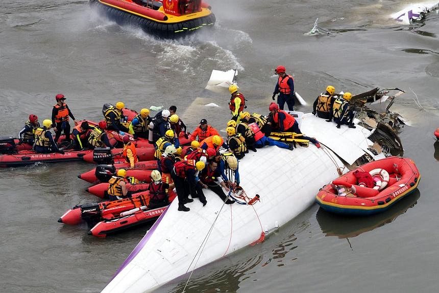 Search and rescue team members operate on a TransAsia Airways passenger plane which crashed into the Keelung River in Taipei, Taiwan on Feb 4, 2015, shortly after taking off from the Taipei Songshan Airport for Kinmen Island. -- PHOTO: EPA
