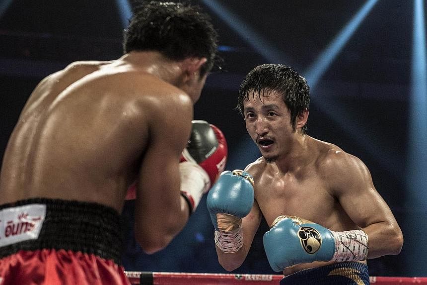 Zou Shiming (right) of China competes against Yokthong Kokietgym of Thailand in their flyweight bout in Macau on Fe 22, 2014.&nbsp;Double Olympic champion Zou has vowed to put China on the global boxing map by winning his first professional world tit