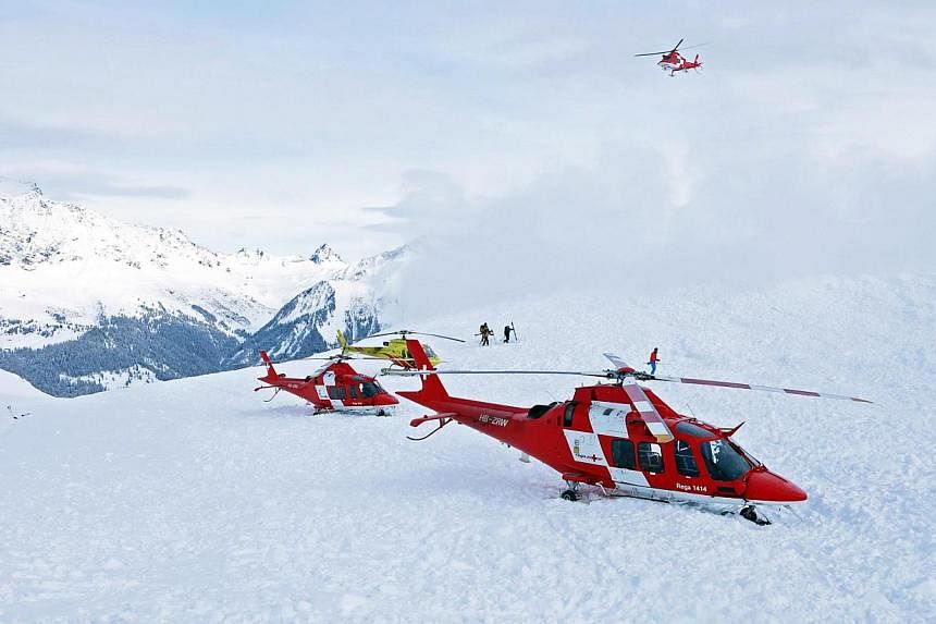 Helicopters and rescue workers of Swiss Air-Rescue service Rega on duty after an avalanche at the Piz Vilan Mountain, eastern Switzerland, on Jan 31, 2014.&nbsp;A 19-year-old American student who disappeared over the weekend while skiing in the Swiss