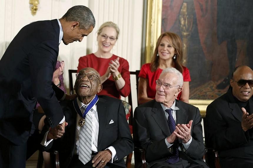 US President Barack Obama presents a Presidential Medal of Freedom to golfer Charles Sifford (front left) as fellow recipients (front row, from right) singer Stevie Wonder,&nbsp;economist Robert Solow, (back row, from right) actress Marlo Thomas&nbsp