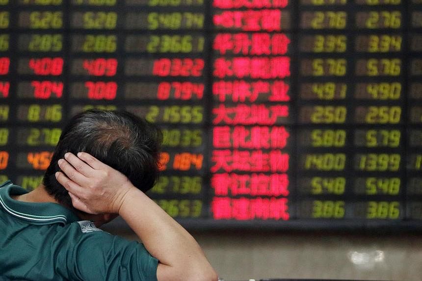 A customer looking at an electronic stock board at a securities firm in Shanghai, China, on July 1, 2013. -- PHOTO: BLOOMBERG