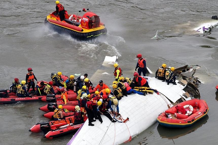 Search and rescue team members operate on a TransAsia Airways passenger plane that crashed into the Keelung River in Taipei, Taiwan, on Feb 4, 2015, shortly after taking-off from the Taipei Songshan Airport for Kinmen Island. Of the 58 people on boar