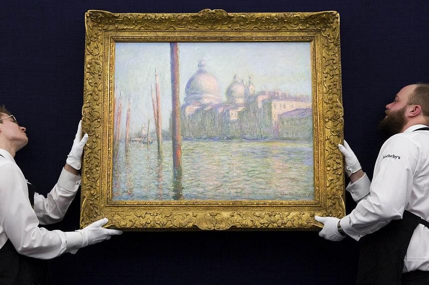 In this Jan 28, 2015 photo, employees of Sotherby's auction house position Le Grand Canal by Claude Monet during a press preview in London. -- PHOTO: AFP