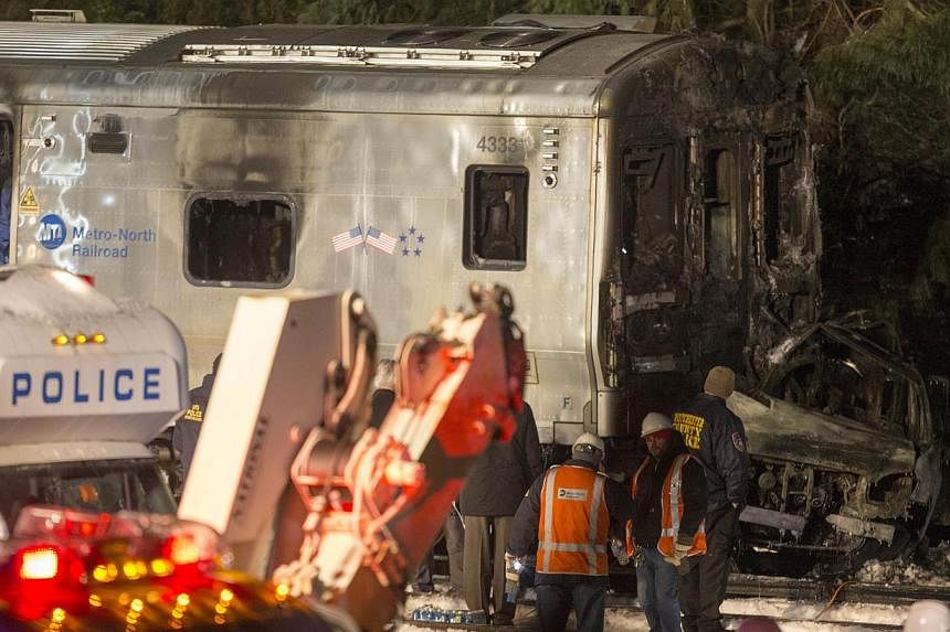 Metropolitan Transportation Authority (MTA) workers and police investigate a Metro-North train crash in Valhalla, New York on Feb 3, 2015. Six people were killed and a dozen injured when a crowded New York commuter train struck a car stalled on the t