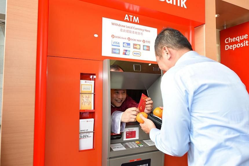 Customers who used their ATM cards at this ‘special’ ATM machine got a surprise as OCBC's cluster manager Clement Tee popped out from behind the screen dressed up as the God of Fortune, and presented them with a $88 red packet and a pair of manda