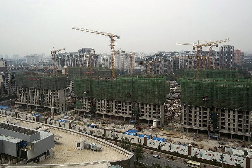 Cranes operating at a residential construction site in the Qinghe district of Beijing, China, on Friday, Sept 12, 2014. -- PHOTO: BLOOMBERG