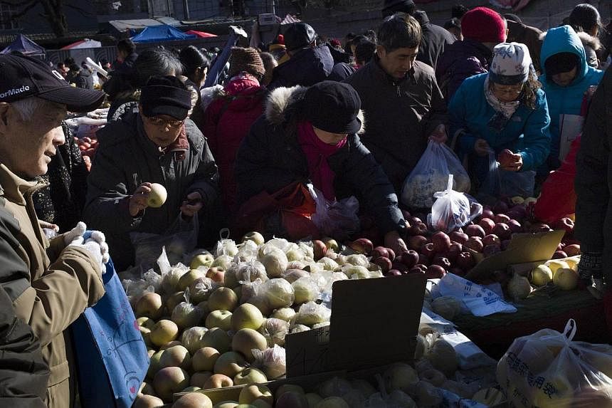 Local residents picking vegetables at a market in Beijing on Dec 5, 2014. -- PHOTO: AFP
