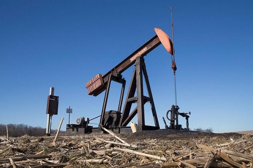 A pump jack, used to extract crude oil from the ground, sits above a well in a farmer's field near Ridgway, Illinois on Jan 21, 2015. -- PHOTO: AFP