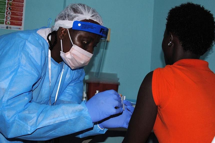 A bandage being placed on the arm of a volunteer after she was administered an experimental Ebola vaccine at Redemption Hospital&nbsp;in New Kru Town, a suburb of Monrovia, on Feb 2, 2015. -- PHOTO: AFP