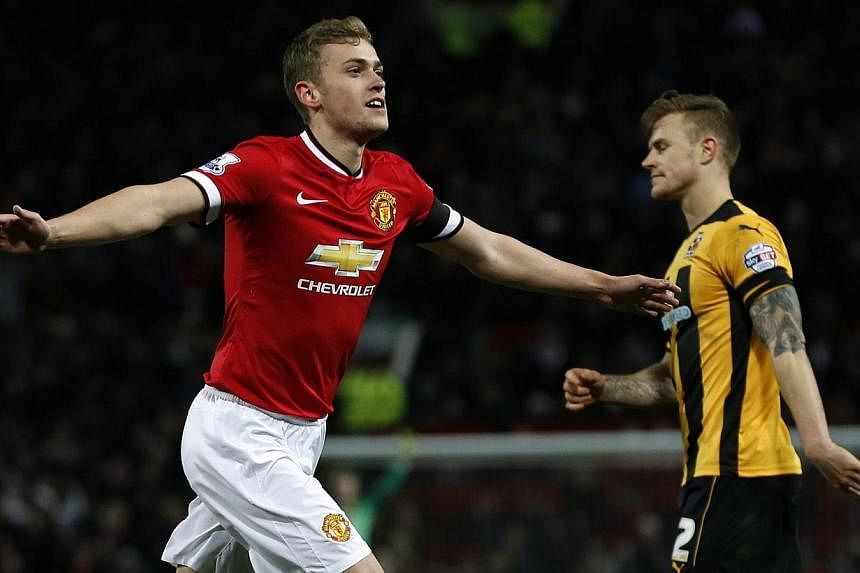Manchester United's James Wilson celebrating after scoring a goal against Cambridge United during their FA Cup fourth round football match at Old Trafford in Manchester on Feb 3, 2015. -- PHOTO: REUTERS