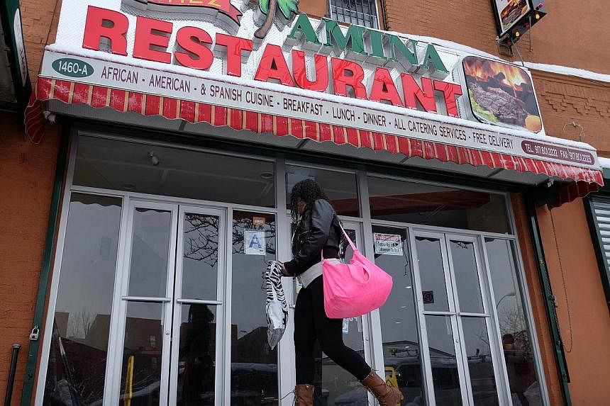 A woman walks past the Chez Amina restaurant in New York's borough of Bronx on Feb 3, 2015. -- PHOTO: AFP