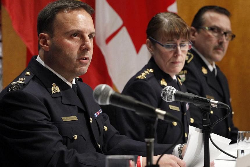 From left to right, Assistant Commissioner James Malizia, of the Royal Canadian Mounted Police (RCMP); Chief Superintendent Jennifer Strachan, RCMP Criminal Operations Office, and Deputy Commissioner Scott Tod listen to reporters' questions at RCMP h