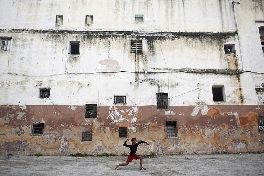&nbsp;Student Ivan Ramos, 15, plays baseball in downtown Havana on Christmas day last year. -- PHOTO: REUTERS