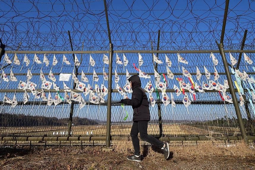 A South Korean tourist walking along a barbed wire fence at the Imjingak peace park at the border city of Paju near the Demilitarized Zone dividing the two Koreas on Jan 1, 2015. An army sergeant has been sentenced to death by a military court for ki