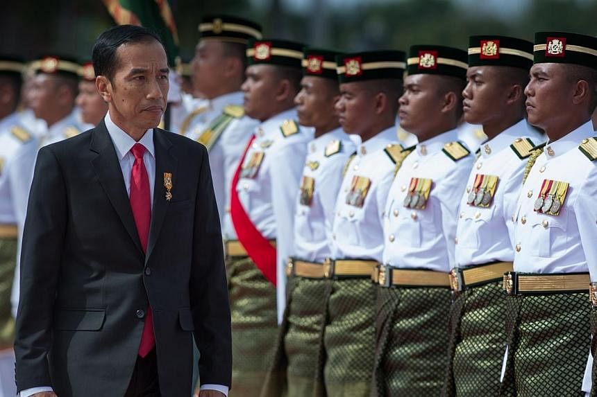 Indonesia's President Joko Widodo inspecting the Royal Malay Regiment Guard of Honour during a welcoming ceremony at the Bunga Raya complex at Kuala Lumpur International Airport in Sepang on Feb 5, 2015. -- PHOTO: AFP
