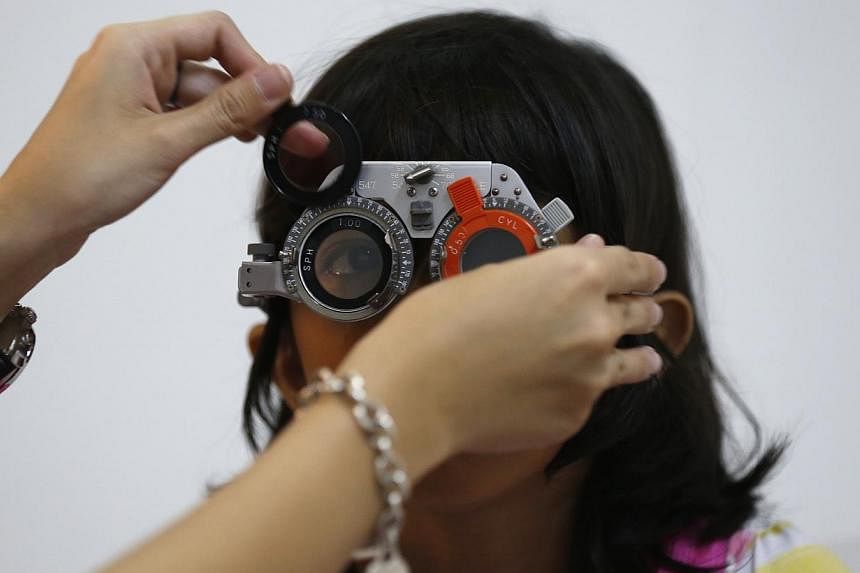 A girl getting her eyes checked for myopia. A China study said poor kids are far less likely to be nearsighted than their wealthier peers. -- PHOTO: ST FILE