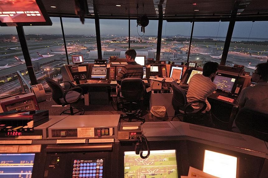 Air traffic controllers working inside the Changi Airport control tower. -- PHOTO: ST FILE
