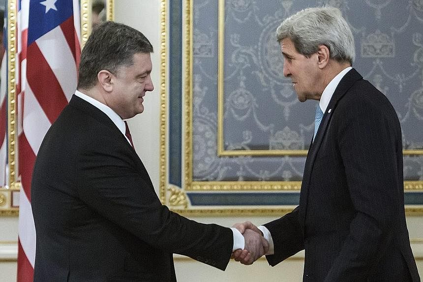 Ukrainian President Petro Poroshenko (left) welcomes US Secretary of State John Kerry (right) during their meeting in Kiev, Ukraine, on Thursday, Feb 5, 2015.&nbsp;Russia on Thursday warned the United States against sending weapons to Ukraine, saying
