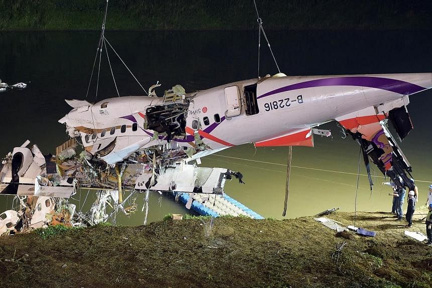 Rescuers lift the wreckage of the TransAsia ATR 72-600 out of the Keelung river at New Taipei City on Feb 4, 2015. -- PHOTO: AFP