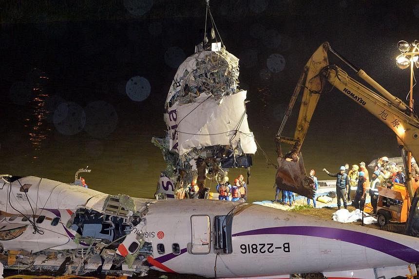 The front section of the wreckage of the TransAsia ATR 72-600 turboprop plane is lifted onto the Keelung river bank outside Taiwan's capital Taipei in New Taipei City on Feb 5, 2015. -- PHOTO: AFP