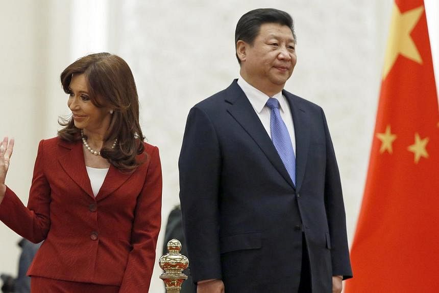 Argentina's President Cristina Kirchner waves as she stands with Chinese President Xi Jinping during a welcoming ceremony in the Great Hall of the People in Beijing Feb 4, 2015. -- PHOTO: REUTERS