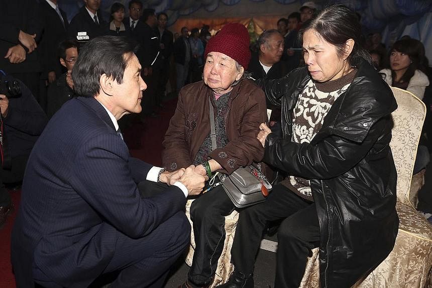 Taiwan President Ma Ying-jeou (left) meets with family members of a passenger who died in a TransAsia Airways plane crash, at a funeral parlor in Taipei Feb 5, 2015. Ma's top strategist King Pu-tsung has resigned from his post as National Security Co