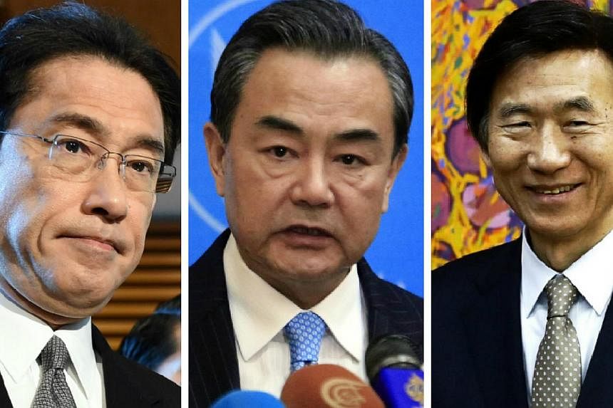 (From left) Japanese Foreign Minister Fumio Kishida and his counterparts Wang Yi of China and Yun Byung Se of South Korea will meet in Seoul in late March, the Yomiuri Shimbun reported. -- PHOTO: AFP / REUTERS / EPA