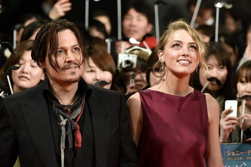 US actor Johnny Depp (left) and partner US actress Amber Heard arrive for the premiere of Mortdecai in Tokyo, Japan, on Jan 27, 2015. -- PHOTO: EPA