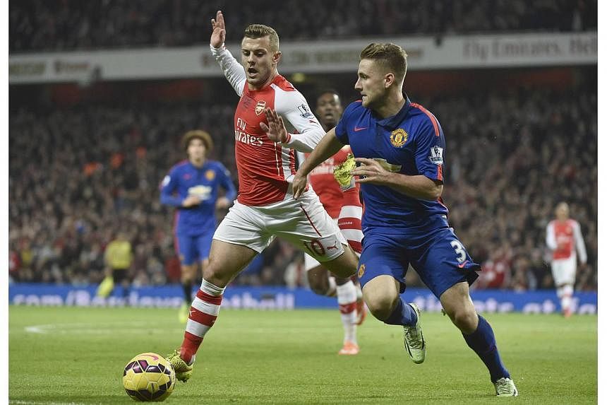 Manchester United's Luke Shaw (right) is challenged Arsenal's Jack Wilshere during their English Premier League soccer match at the Emirates Stadium in London Nov 22, 2014. Wilshere needs to "master his own life" after being pictured this week holdin