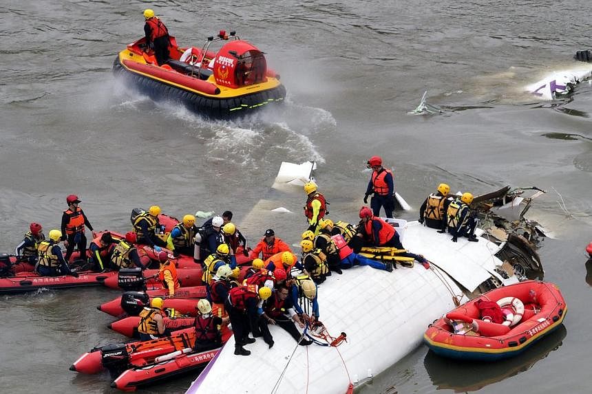Search and rescue team members operate on a TransAsia Airways passenger plane that crashed into the Keelung River in Taipei on 04 February 2015. -- PHOTO: EPA
