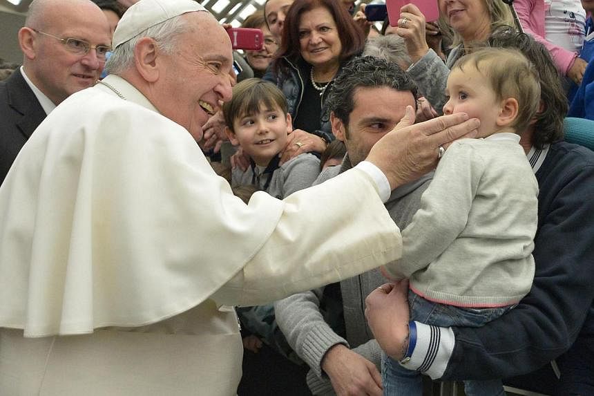 Pope Francis greets a child during a general audicence in the Vatican City on Jan 28, 2015. -- PHOTO: EPA