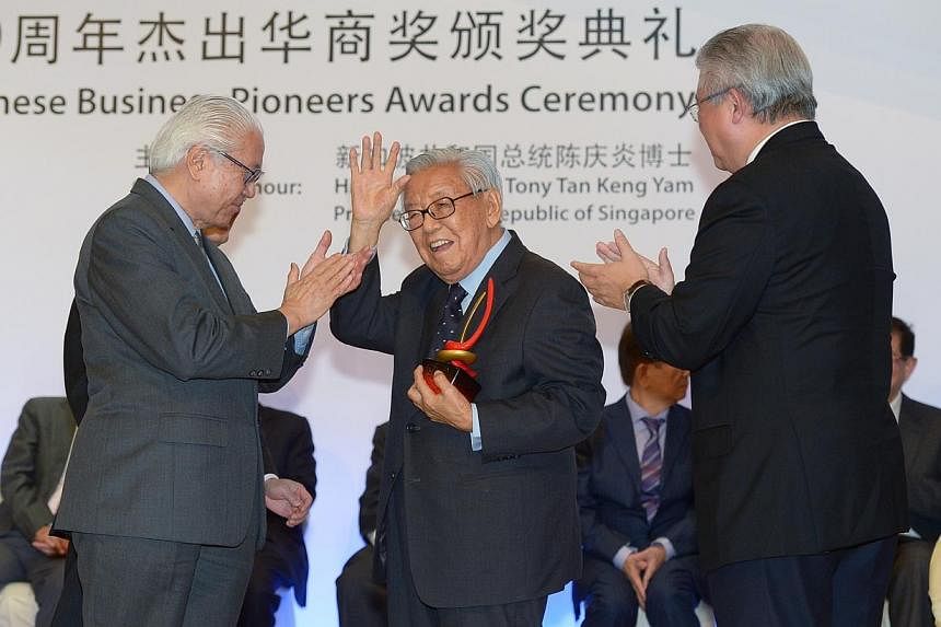 One of the award recipients was Mr Tao Shing Pee, (centre), chairman of real estate developer Shing Kwan Group, who, at 99 years old, was also the oldest among them. He received the award from President Tony Tan (left). -- ST PHOTO: DESMOND WEE