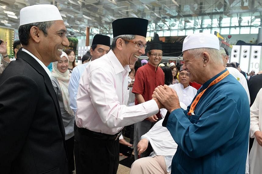 Minister-in-charge of Muslim Affairs Yaacob Ibrahim speaking to former MP Wan Hussin Zoohri at Changi Airport on Sep 26, 2014, before the latter’s departure to Mecca. An increase in the Hajj quota would help the many Singaporeans on the waiting lis