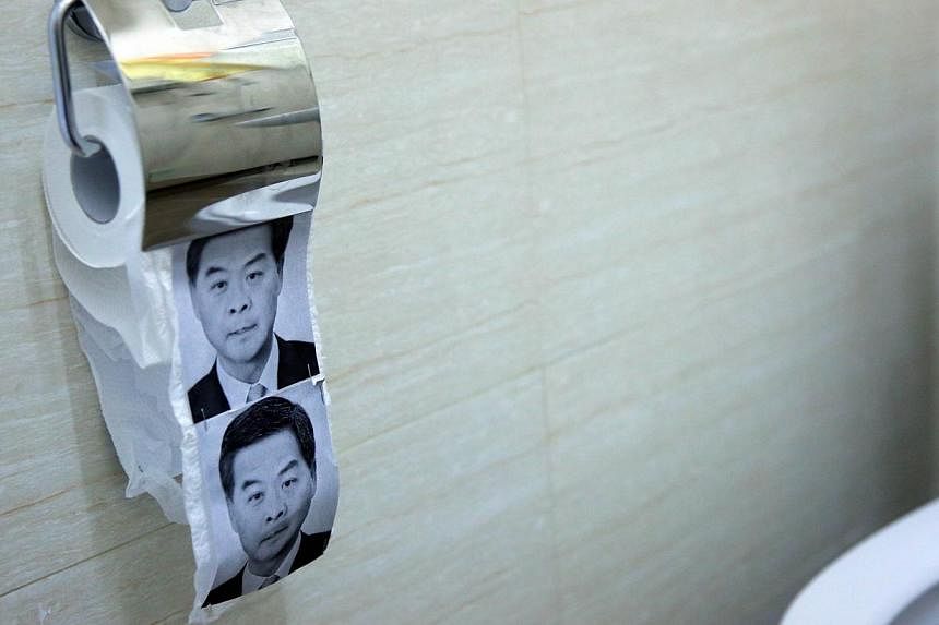 This photo taken on Dec 23, 2014 shows novelty toilet paper with the image of Hong Kong's Chief Executive Leung Chun-ying (right) in a flat turned into a recreation of the main pro-democracy protest site in Hong Kong. -- PHOTO: AFP