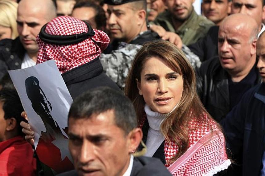 Jordan's Queen Rania (centre) holds a picture of recently executed Jordanian pilot Maaz al-Kassasbeh, with the words in Arabic reading "Maaz is a martyr of right", during a march after Friday prayers in downtown Amman Feb 6, 2015. -- PHOTO: REUTERS