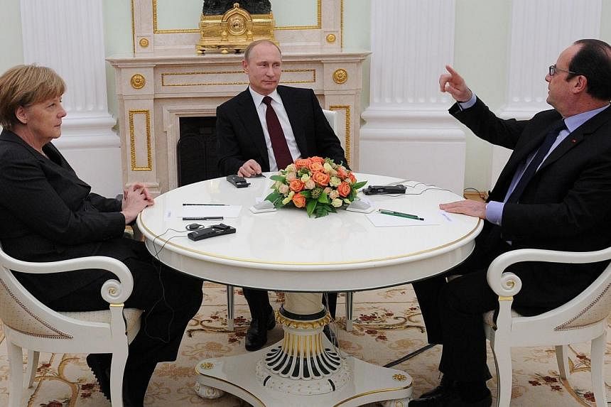 French President Francois Hollande (right) gestures as he speaks with Russian President Vladimir Putin (centre) and German Chancellor Angela Merkel during a meeting at the Kremlin in Moscow on Feb 6, 2015. -- PHOTO: AFP