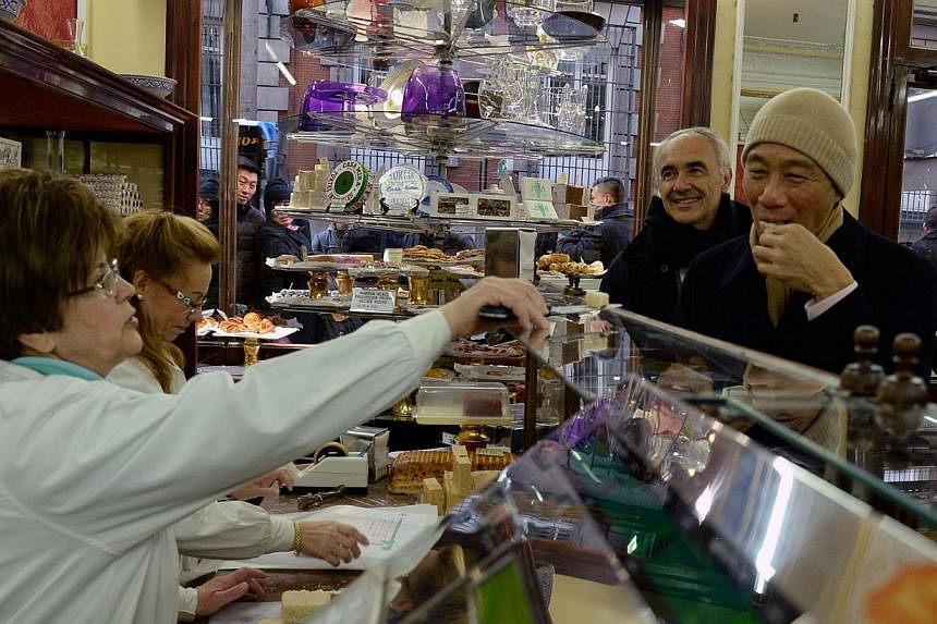 PM Lee Hsien Loong taking an evening tour of Madrid's old city quarter on the Feb 5 2015. Here, he gets a taste of some traditional Spanish dessert at an old confectionary with Honourary Consul-General of Singapore in Madrid Alfonso Vegara.&nbsp;-- P
