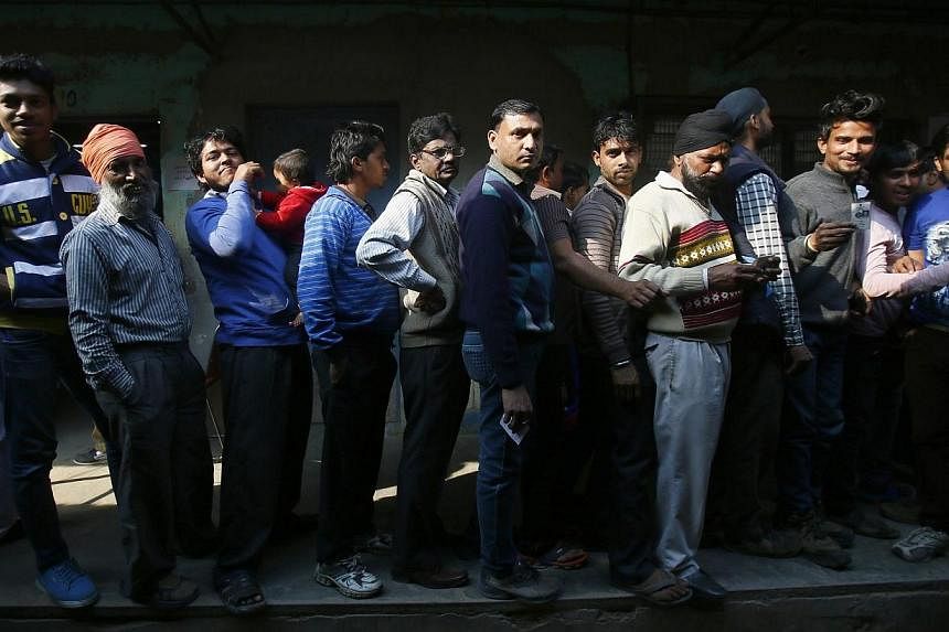 Voters standing in queue to cast their votes at a polling station during the state assembly election in New Delhi on Feb 7, 2015. -- PHOTO: REUTERS