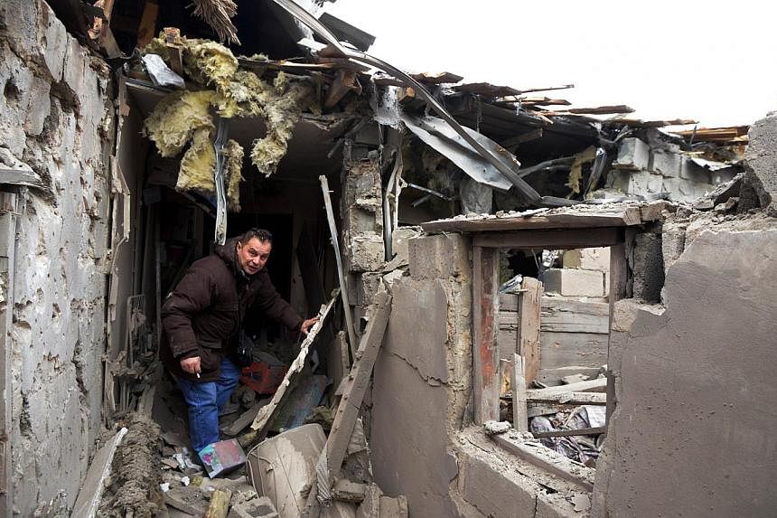 A man walks in a house destroyed after shelling in the Leninsky district of the eastern Ukrainian city of Donetsk on Feb 8, 2015.&nbsp;-- PHOTO: AFP