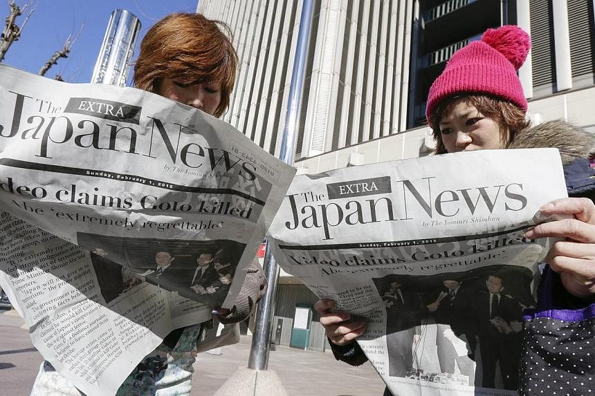 Japanese women read newspapers reporting about a video released online purportedly showing the execution of Japanese hostage kenji Goto by Islamic State in Iraq and Syria (ISIS) militants, in Tokyo, Japan on Feb 1, 2015.&nbsp;Japan has seized the pas