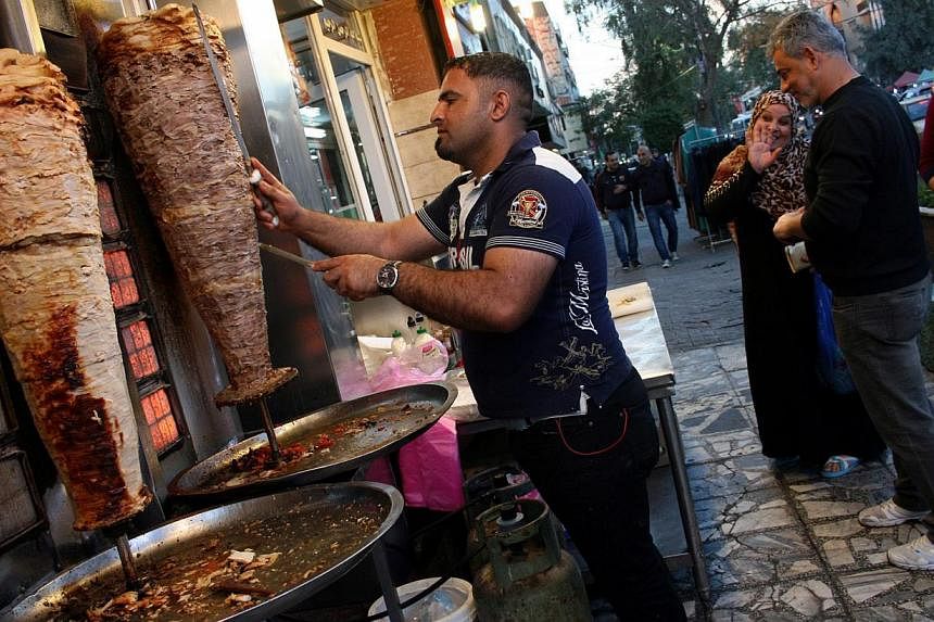 An Iraqi vendor sells shawarma at a restaurant in central Baghdad Feb 7, 2015. Iraqi Prime Minister Haider al-Abadi announced that a decade-long nighttime curfew in the capital will be lifted on Feb 7. -- PHOTO: EPA