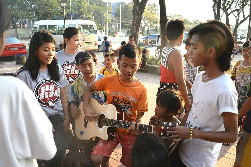 Ricky Nieco (right), 19, was a street child when he was five till his grandmother plucked him out of the streets when he turned seven. He now volunteers for Childhope Philippines, the non-profit organisation helping children who live off Manila's mea
