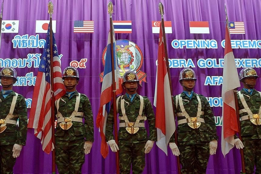 Thai soldiers carry national flags of the participating nations as they parade during the opening ceremony for the annual combined military exercises coined Cobra Gold 15 at Armed Forces Academies Preparatory School in Nakhon Nayok province on Feb 9,