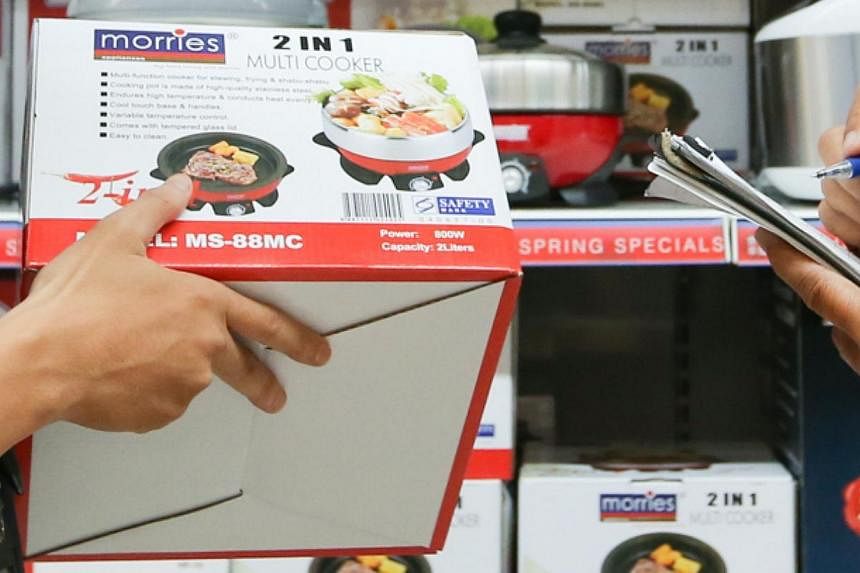 CERTIS Cisco enforcement officers checking for the Safety Mark sticker on electronic products sold in NTUC.&nbsp;Consumers who own electric bowls from the brands Nushi, T.M.D and T.A.C are advised to stop using them immediately if their appliances do