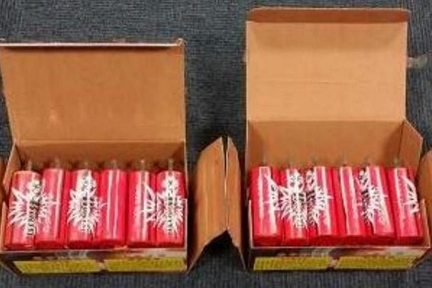 The two boxes of "boom" firecrackers uncovered from the car boot, which also contained 24 strips of firecrackers. -- PHOTO: ICA&nbsp;