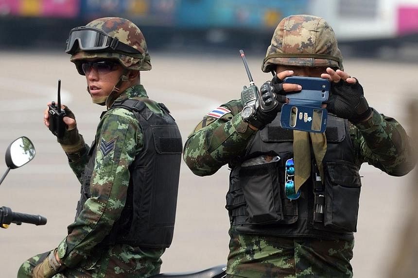 A Thai soldier taking picture of members of the media as they stand guard during a visit by Chaturon Chaisang, a former education minister, at an army base in Bangkok on Jan 29, 2015.&nbsp;Four people were lightly injured in a blast in an army ordnan