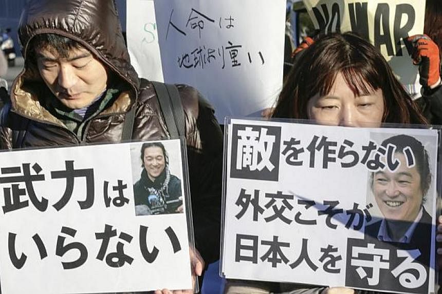 Mourning demonstrators hold a silent prayer rally and protest against Japanese Prime Minister Shinzo Abe's behavior and the murder of hostages held by Islamic State in Iraq and Syria (ISIS) militants, in Tokyo, on Feb 1, 2015.&nbsp;Tokyo on Monday, F